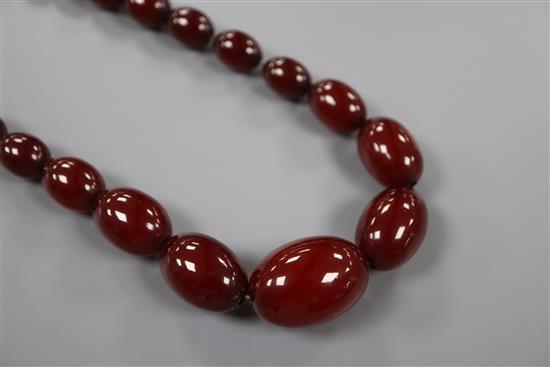 A single strand graduated simulated cherry amber bead necklace, 72cm, gross 61 grams.